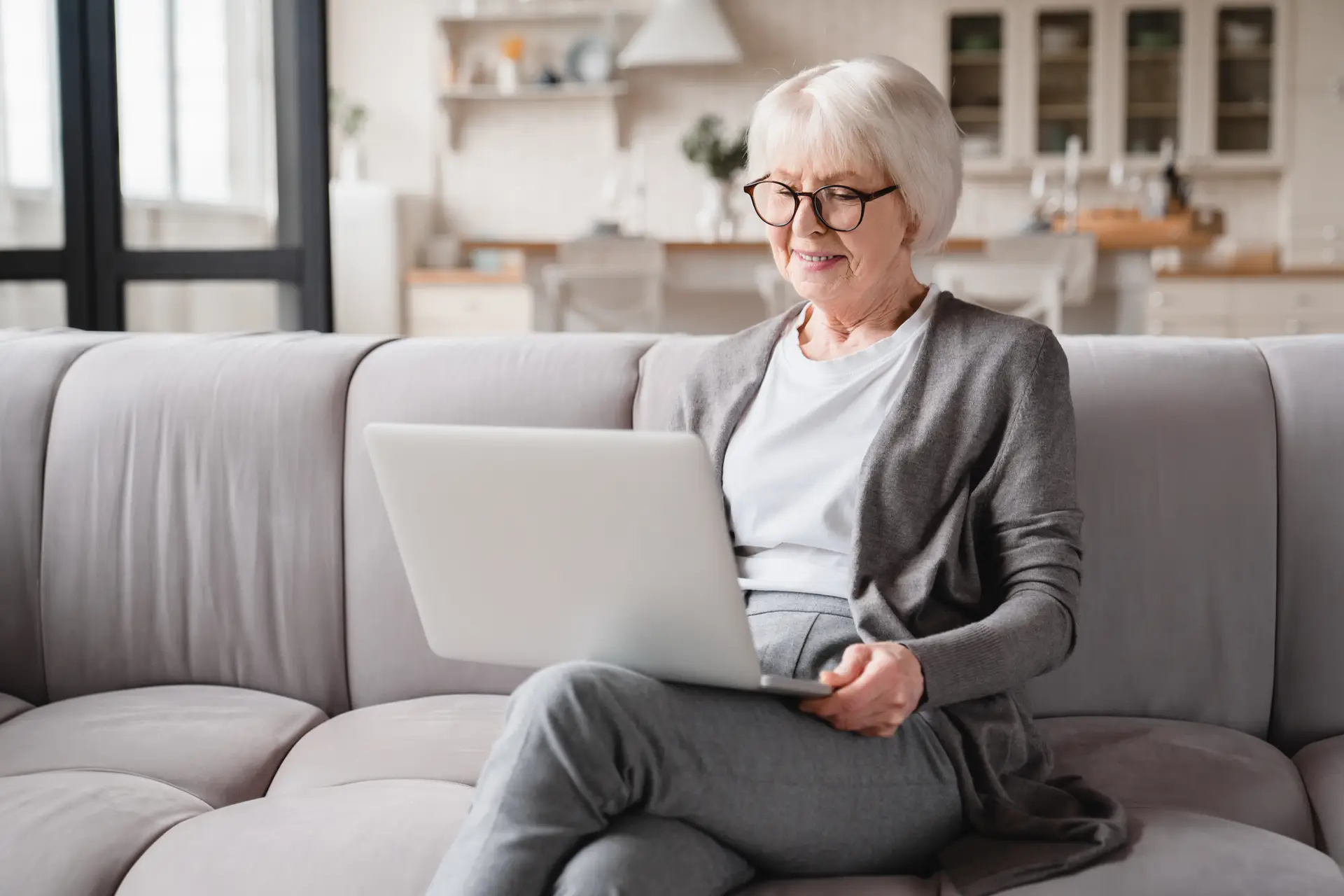 grandmother using laptop online, working remotely, checking pension, freelance job at home